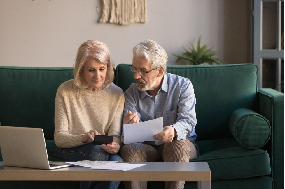Elderly couple go over their budget at home in the living room.
