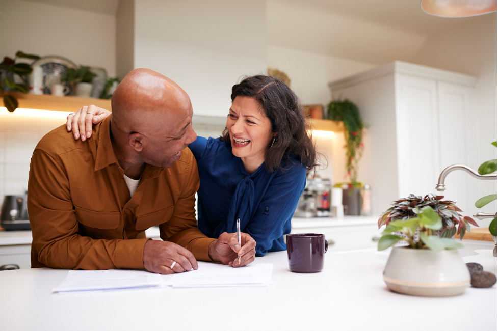 Middle aged couple review their finances in the kitchen.